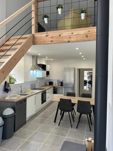 une cuisine avec une table et des chaises ainsi qu'un escalier dans l'établissement Maison d'Amie, à Ajoux