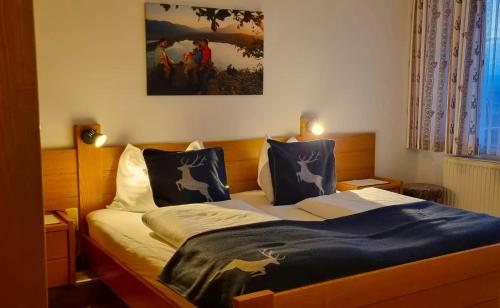 Un dormitorio con una cama y un cuadro en la pared. en Hotel Baumgartnerhof, en Altfinkenstein