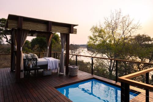 a bed on a deck next to a swimming pool at Simbavati Hilltop Lodge in Timbavati Game Reserve