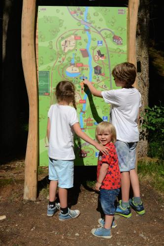 three children standing in front of a map at Boutique Hotel Am Park in Valdaora