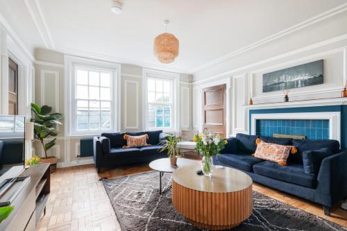 a living room with blue couches and a coffee table at The Vicarage Tooting, SW17 in London