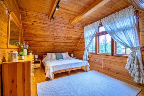 a bedroom with a bed in a log cabin at Mazurski dom nad jeziorem in Łysa Góra