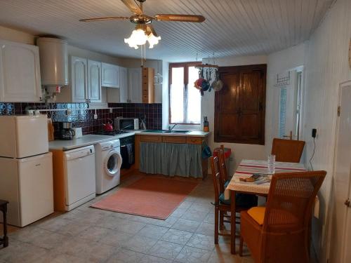 une cuisine avec des appareils blancs et une table avec des chaises dans l'établissement Heaven's Cottage, à Cieux