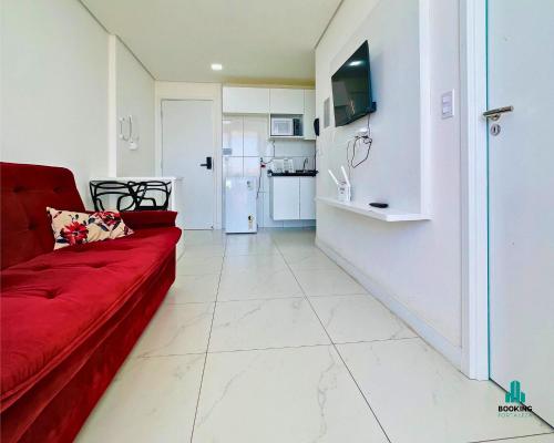 a living room with a red couch and a kitchen at Aquarius Residence by Holiday Stays in Fortaleza
