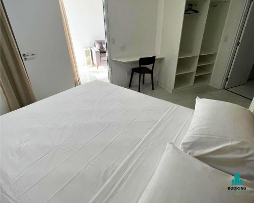a white bed in a bedroom with a chair at Aquarius Residence by Holiday Stays in Fortaleza