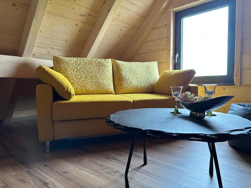 a living room with a yellow couch and a table at Der Welfenshof in Malschwitz