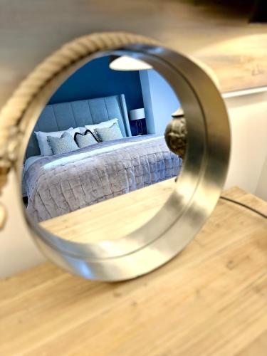 a mirror reflecting a bed in a bedroom at Stylish Apartment with BBQ Kensington in London