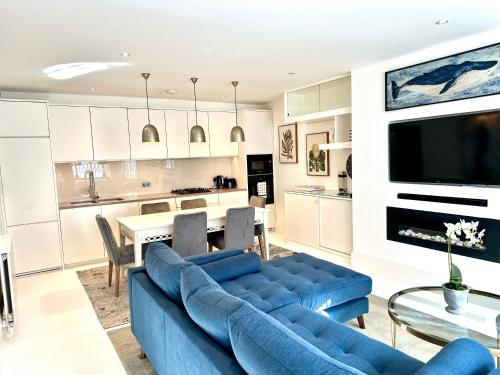 a living room with a blue couch and a table at Stylish Apartment with BBQ Kensington in London