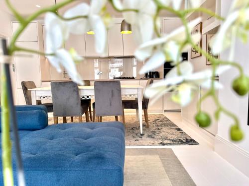 a living room with a blue couch and a table at Stylish Apartment with BBQ Kensington in London