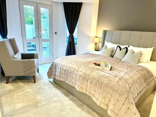 a bedroom with a large bed and a chair at Stylish Apartment with BBQ Kensington in London
