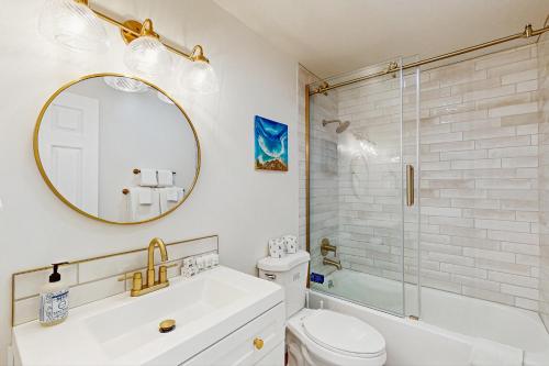 een badkamer met een wastafel, een toilet en een spiegel bij The Sunny Saddle in Incline Village