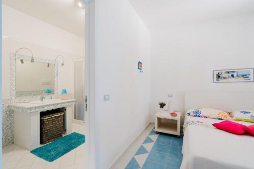 a bedroom with a bed and a sink and a mirror at Deliziosa Villa Patrizia a Otranto in Otranto