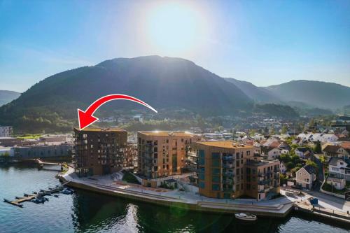 an aerial view of a city with a red arrow at Penthouse with fjord view and parking in Sogndal