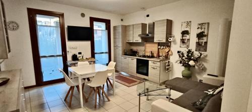 a kitchen and living room with a table and a couch at La Casa al Mare di Rossella in Cavallino-Treporti