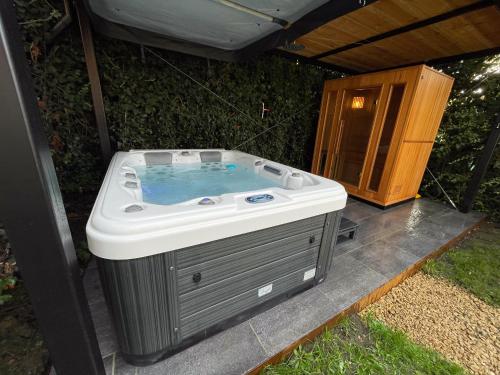 a hot tub sitting in the middle of a patio at Loft du presbytère - Calme et nature in Beauraing