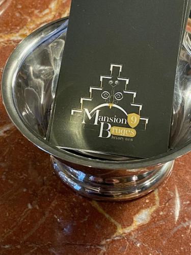 a bottle of wine in a glass on a table at Mansion9Bruges in Bruges