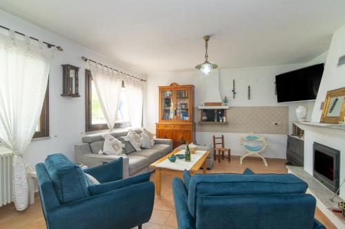 a living room with a couch and two chairs at Perla in Torpè