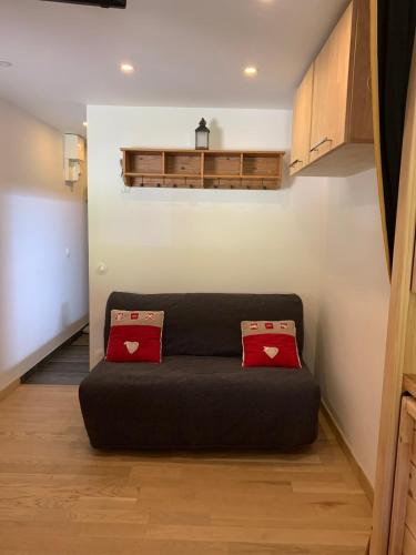 - un canapé dans le salon avec deux oreillers rouges dans l'établissement La Plagne Bellecôte Résidence 3000, à La Plagne Tarentaise