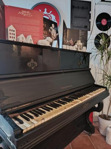 a black piano sitting inside of a room at Berlin's Guest House in Urla