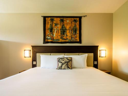 a bedroom with a large white bed with two pillows at Chessington Resort Hotel in Chessington
