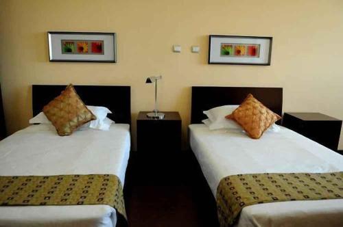 two beds in a hotel room with two at Destiny Addis Hotel in Addis Ababa