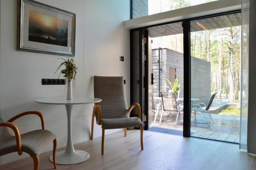 a dining room with a table and chairs and a patio at Beach house in Lohusalu - for extra cost sauna and barrel bath in Laulasmaa