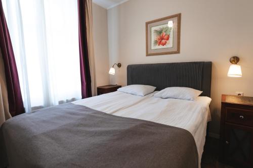 a hotel room with a bed and a window at Forums Boutique Hotel in Rīga