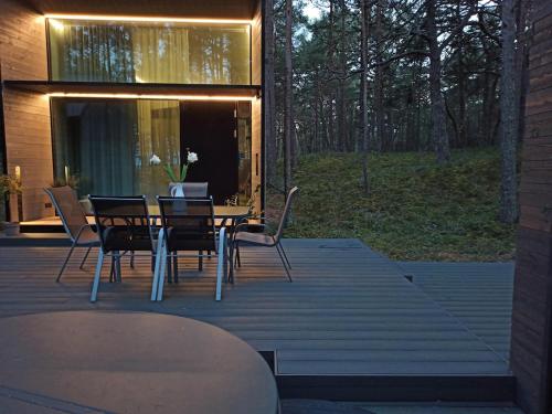 a table and chairs on a deck with a laptop on it at Beach house in Lohusalu - for extra cost sauna and barrel bath in Laulasmaa