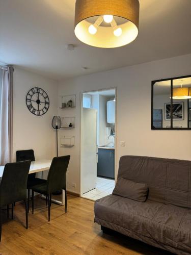 un salon avec un canapé et une table dans l'établissement Logement au pied de la gare, à Pontoise