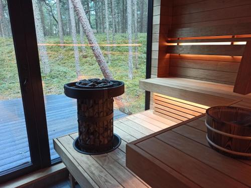 a porch of a sauna with a bench and a window at Beach house in Lohusalu - for extra cost sauna and barrel bath in Laulasmaa