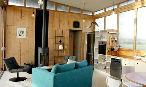 un salon avec un canapé bleu et une cheminée dans l'établissement LA FERME DU MARAIS GIRARD (Villas), à Bretignolles-sur-Mer