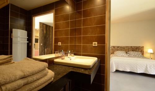 ein Badezimmer mit Waschbecken und Bett in der Unterkunft LA FERME DU MARAIS GIRARD (Villas) in Brétignolles-sur-Mer