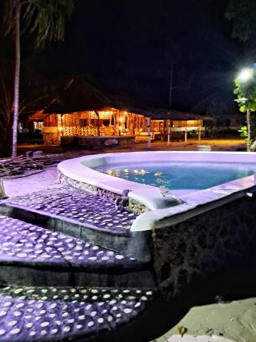 a swimming pool at night with a house in the background at Villa Tua, Beach Pool & Spa in Letman