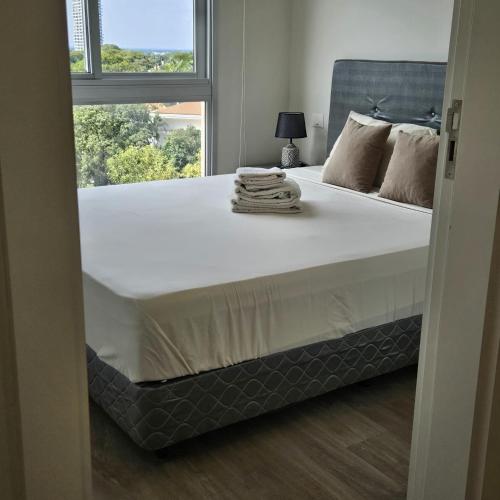 a bedroom with a large white bed with a window at MODERN APARTMENT, 1 HAB, Piscina, ZONA Shopping del Sol in Asuncion