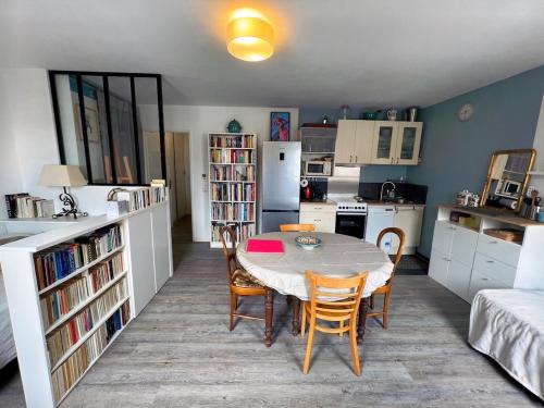 une cuisine avec une table et des chaises dans une pièce dans l'établissement Studio cosy près de Paris et de l'Aéroport CDG, à Drancy