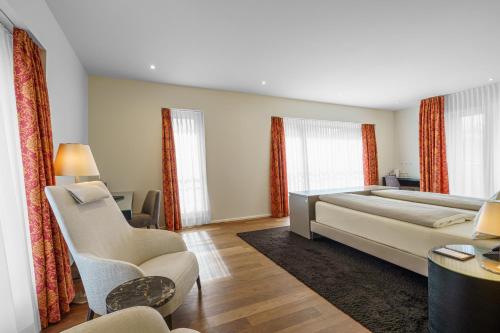 a bedroom with a large bed and a couch at Hotel Du Nord in Interlaken