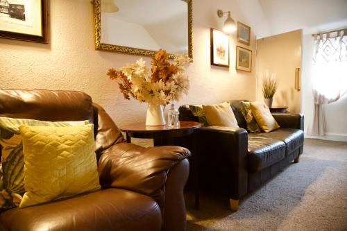 a living room with a leather couch and a table at The Kings Arms in Stafford
