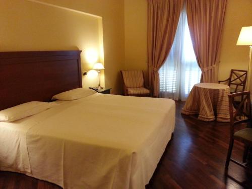 a hotel room with a white bed and a window at Grand Hotel Baia Verde in Catania