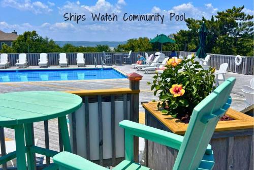 a patio with a table and chairs next to a pool at The Earnest at Ships Watch in Duck