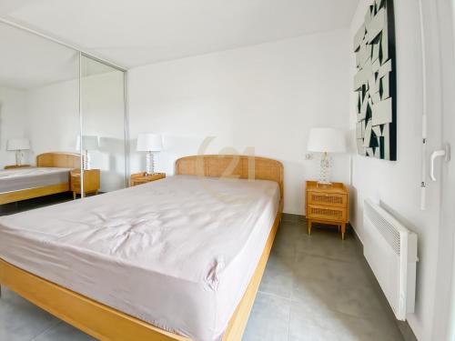 une chambre avec un grand lit et deux tables de nuit dans l'établissement Charmant T2 Ile Rousse, proche centre ville, à LʼÎle-Rousse
