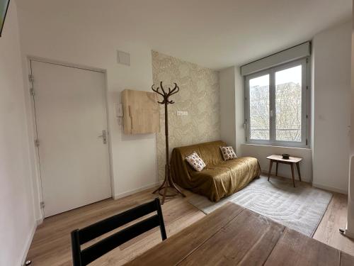 un salon avec un canapé et une fenêtre dans l'établissement Calvi - Paisible et chaleureux, à Reims