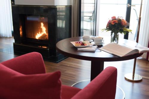 a table with a plate of food and a fireplace at Bad Horn - Hotel & Spa in Horn