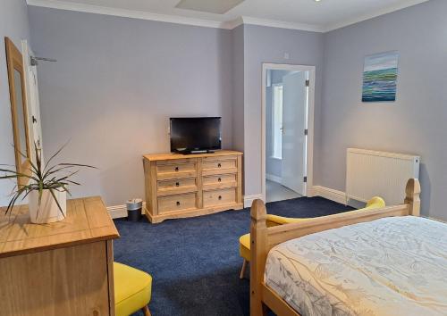 a bedroom with a bed and a tv on a dresser at Comfortable and Spacious - Guest Room 7 in Cranleigh