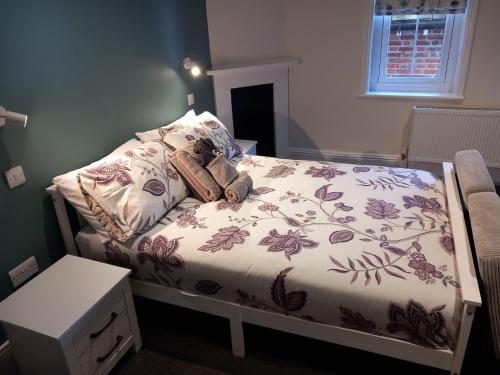 a bedroom with a bed with a teddy bear on it at Comfortable Spacious Double Ensuite Room in Cranleigh