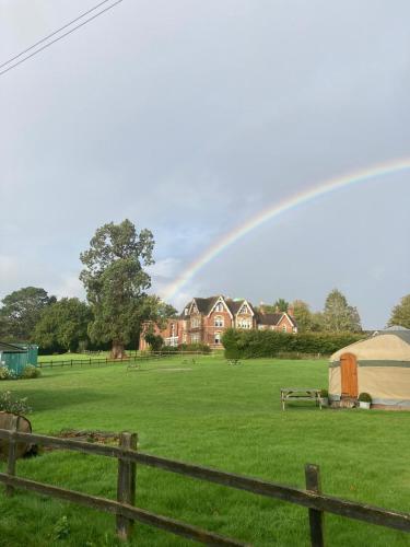 a rainbow over a field with a house and a tent at Comfortable Spacious Double Ensuite Room in Cranleigh
