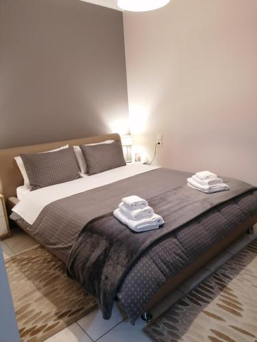 a bedroom with a large bed with two towels on it at ANNA'S HOME Ιωάννινα in Ioannina