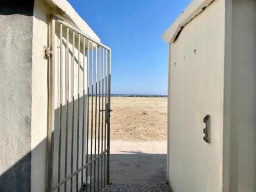 una puerta abierta que conduce a una playa con arena en Dimora storica con accesso privato alla spiaggia - Villa Drei, en Rímini