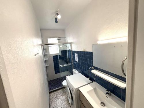 une salle de bain avec un lavabo, des toilettes et un miroir dans l'établissement Maison cosy avec terrasse, clim et parking, à 250m de la plage - FR-1-229C-662, à Port-la-Nouvelle
