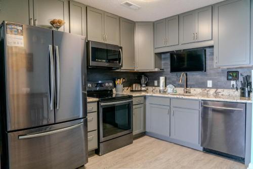 a kitchen with stainless steel appliances and white cabinets at Sea Pond Villa Unit 3 in Myrtle Beach