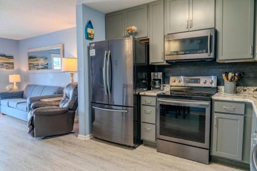 a kitchen with a stainless steel refrigerator and a couch at Sea Pond Villa Unit 3 in Myrtle Beach